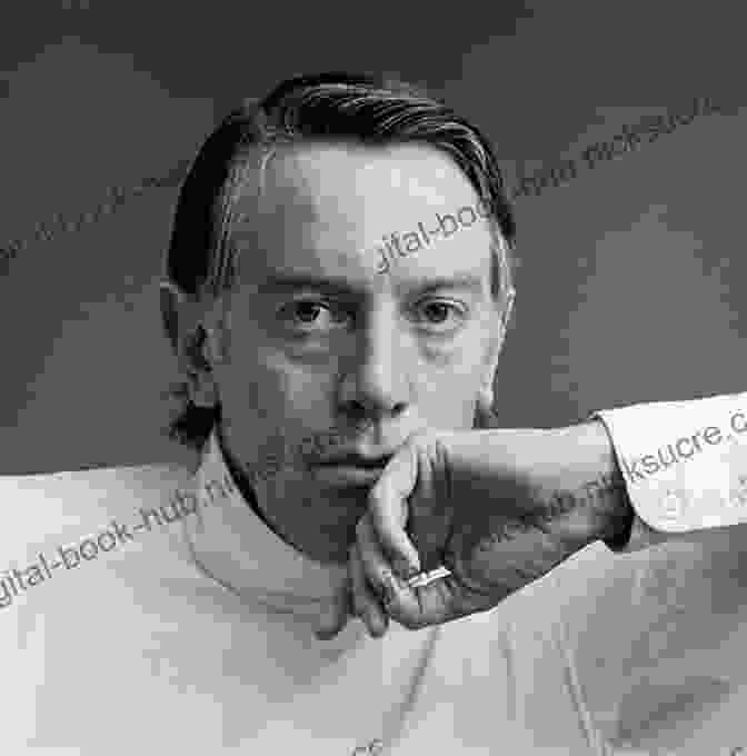 Kenneth Tynan, A Prominent Theater Critic And Cultural Icon, Is Shown In A Black And White Photograph. He Is Seated At A Desk, Smoking A Cigarette And Looking Directly At The Camera. He Has A Thoughtful Expression On His Face And Is Wearing A Suit And Tie. Profiles Kenneth Tynan